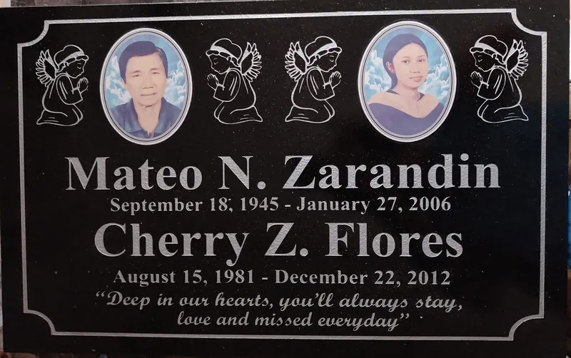 Black granite lapida with two oval ceramic portraits, praying angel engravings and silver lettering