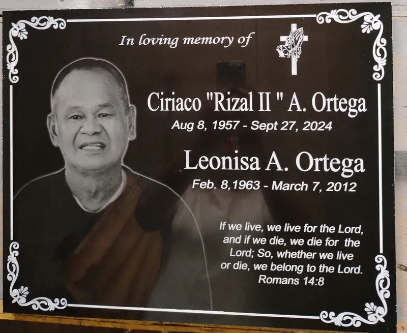 Black granite lapida with a laser-etched portrait, scroll border and white lettering for two names